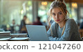 A beautiful female student is using a networked laptop to research information within the college. 121047260
