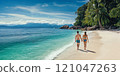 A tourist couple walks hand in hand along a beautiful beach on their honeymoon. 121047263