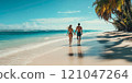 A tourist couple walks hand in hand along a beautiful beach on their honeymoon. 121047264
