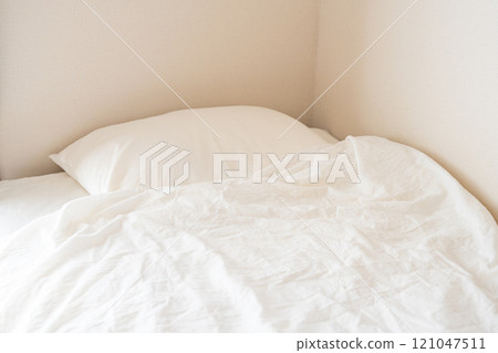 A simple bed with white sheets A simple bed with white sheets 121047511