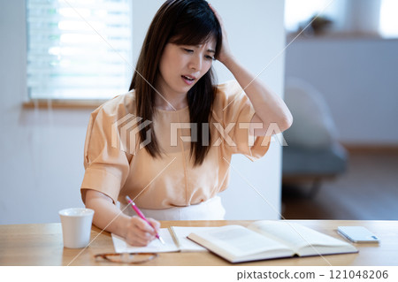 中年婦女在餐桌上學習時擔心 121048206