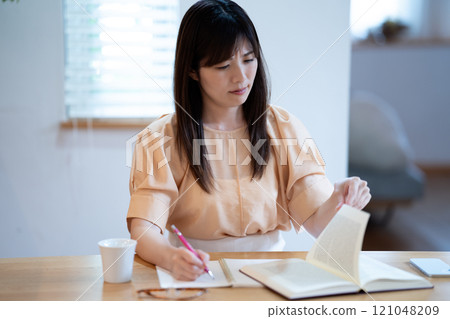 中年婦女在餐桌上學習時擔心 中年婦女在餐桌上學習時擔心 121048209