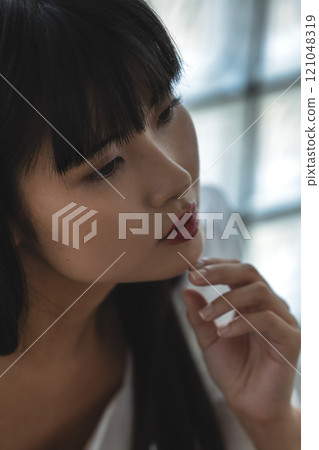 Close-up of a young woman with blunt bangs 121048319