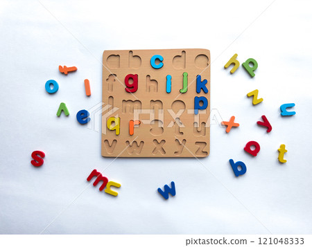 Colorful alphabet puzzle with wooden board and loose letters on white background Colorful alphabet puzzle with wooden board and loose letters on white background 121048333