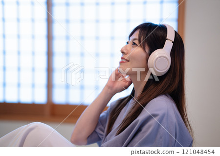 Middle-aged woman listening to music in a Japanese-style room 121048454