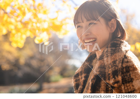 Young woman enjoying autumn leaves hunting 121048600
