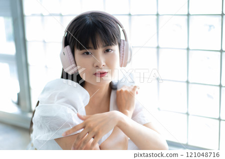 A young woman listening to music with headphones A young woman listening to music with headphones 121048716