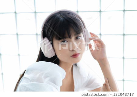 A young woman listening to music with headphones A young woman listening to music with headphones 121048717