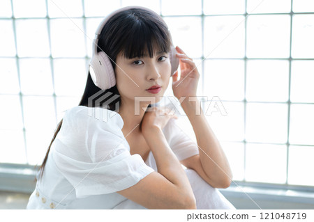 A young woman listening to music with headphones A young woman listening to music with headphones 121048719