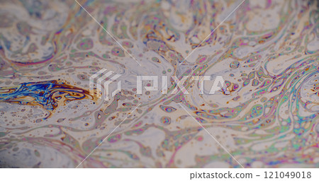 Gasoline rainbow. Oil dye droplets. Defocused multicolor purple green liquid paint curve acrylic slick on dark black blurred light abstract art background. 121049018