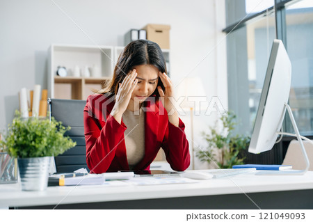 Business woman is stressed, bored, and overthinking from working on a tablet at the office. Business woman is stressed, bored, and overthinking from working on a tablet at the office. 121049093