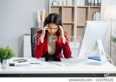 Business woman is stressed, bored, and overthinking from working on a tablet at the office. 121049126