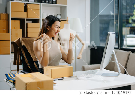 Young business owner woman prepare parcel box and standing check online orders for deliver Young business owner woman prepare parcel box and standing check online orders for deliver 121049175