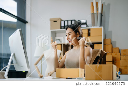 Young business owner woman prepare parcel box and standing check online orders for deliver Young business owner woman prepare parcel box and standing check online orders for deliver 121049273