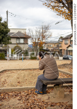 A middle-aged woman worried alone in an autumn park 121049467