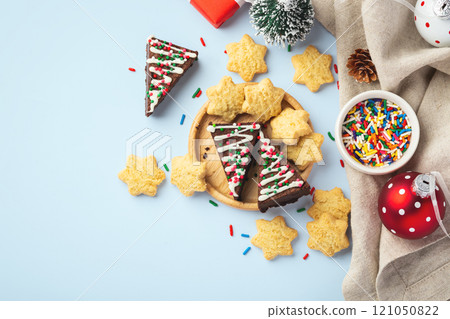 Chocolate brownie and star cookies with christmas decorations on napkins on blue background, top view Chocolate brownie and star cookies with christmas decorations on napkins on blue background, top view 121050822