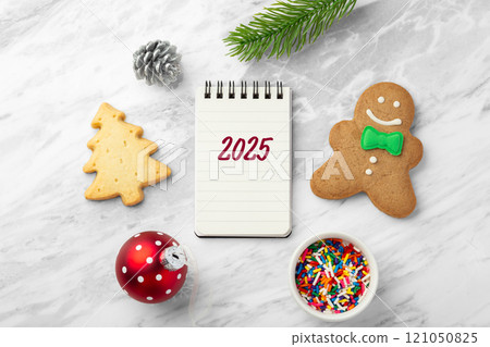 2025 christmas background with notebook, gingerbread man and christmas ball on marble table 2025 christmas background with notebook, gingerbread man and christmas ball on marble table 121050825