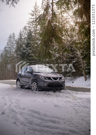 Black SUV Parked on Snowy Forest Road 121051373
