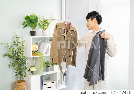 Asian man choosing clothes-simple room background 121052496