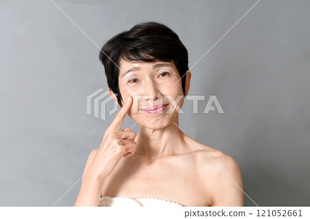 微笑的中年亞洲女性用手指指著臉頰 121052661