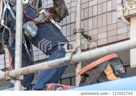 [Workers building scaffolding during large-scale apartment repair work] 121052783
