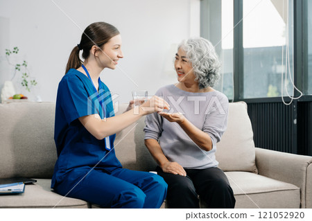 Caregiver doctor examine older patient use blood pressure gauge. woman therapist nurse at nursing home taking care of senior elderly woman 121052920