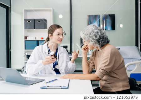 Portrait of female doctor explaining diagnosis to her patient. Doctor Meeting With Patient In Exam Room. A medical practitioner reassuring a patient Portrait of female doctor explaining diagnosis to her patient. Doctor Meeting With Patient In Exam Room. A medical practitioner reassuring a patient 121052979
