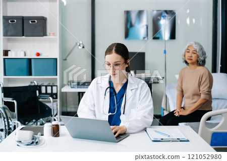Young female doctor in white medical uniform using laptop and tablet talking video conference call at desk,Doctor sitting at desk and writing a prescription for her patient Young female doctor in white medical uniform using laptop and tablet talking video conference call at desk,Doctor sitting at desk and writing a prescription for her patient 121052980
