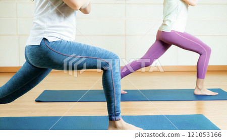 Close-up of lower body of people exercising in yoga 121053166