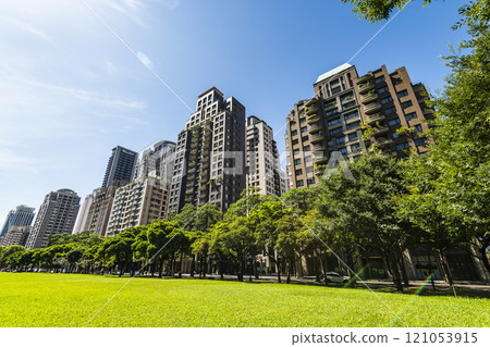 Low-angle view of green park space and modern buildings on both sides in downtown Taichung, Taiwan, It is near the National Taichung Theater. 121053915