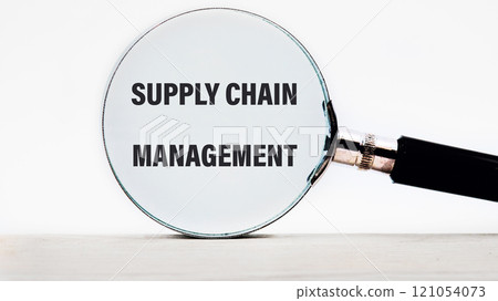 Business concept. SUPPLY CHAIN MANAGEMENT words through a magnifying glass on a light background 121054073