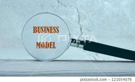 Business concept. BUSINESS MODEL text written through a magnifying glass in the background 121054076