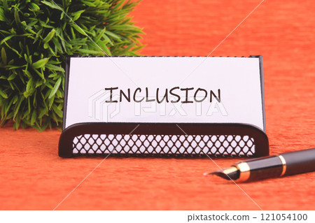 Business concept. The conceptual phrase INCLUSION written on the business card, front view Business concept. The conceptual phrase INCLUSION written on the business card, front view 121054100