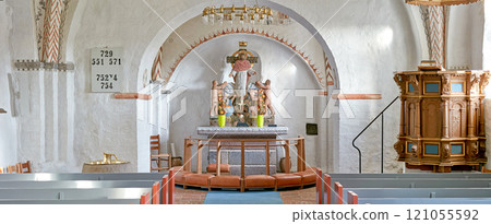 Interior of a historical church with rows of benches, a pulpit, nave or alter with kneeler cushions and sacred figure of Jesus on a cross. 12th century old Danish National Church in Faarup, Denmark Interior of a historical church with rows of benches, a pulpit, nave or alter with kneeler cushions and sacred figure of Jesus on a cross. 12th century old Danish National Church in Faarup, Denmark 121055592