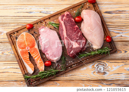 Mix of raw meat and fish . Salmon , beef , pork , chicken staek . Top view Mix of raw meat and fish . Salmon , beef , pork , chicken staek . Top view 121055615