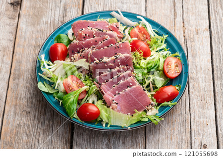 Salad with raw tuna , sesame and cherry tomatoes photography . Top view 121055698