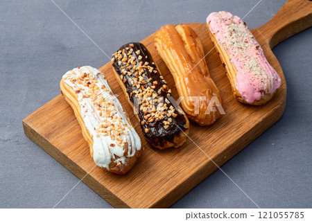 Assorted eclairs on a pastel top view Traditional French dessert 121055785