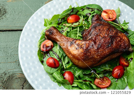 Grilled chicken legs with tomatoes and salad . Top view Grilled chicken legs with tomatoes and salad . Top view 121055829
