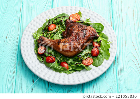 Grilled chicken legs with tomatoes and salad . Top view 121055830