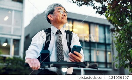 Businessman, phone or electrical bike for urban travel, clean energy or sustainable transport. Thinking, mature and eco friendly bicycle with mobile app for location, city commute or map in Japan 121056107