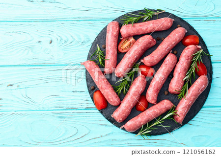 Raw beef sausages with rosemary and tomatoes photography . Top view 121056162