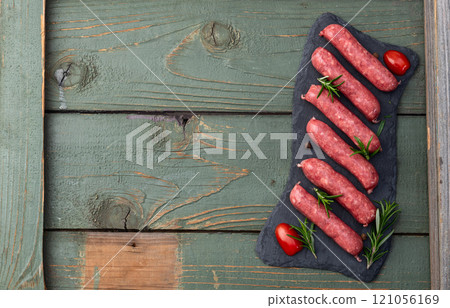 Raw beef sausages with rosemary and tomatoes photography . Top view Raw beef sausages with rosemary and tomatoes photography . Top view 121056169