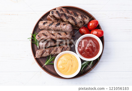 Grilled beef sausages with rosemary sauce and tomatoes photography . Top view Grilled beef sausages with rosemary sauce and tomatoes photography . Top view 121056183
