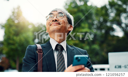 Thinking, business and man with phone in city for communication, planning travel and schedule update. Mature, person and mobile app for corporate negotiation, location search and information in Japan 121056257