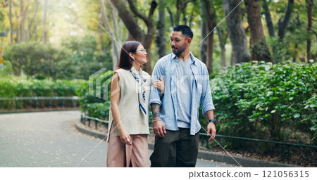 Couple, conversation and walking in calm park of Japan, love and bonding on honeymoon vacation. People, security and outdoor support on holiday in nature, travel together and explore relationship 121056315