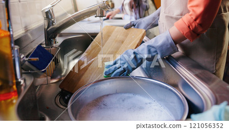 Hands, girl and mom for washing dishes in kitchen, learning and helping with hygiene in apartment. People, mother and daughter with routine, teaching and cleaning with water at family house in Japan 121056352