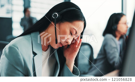 Burnout, headache and Japanese woman in call center with stress, pain or fatigue in office. Tired consultant, breakdown or frustrated sales agent in telemarketing with depression or migraine in Japan 121056828