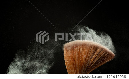 Big Soft Makeup brush with powder explosion. Cosmetic brush splash powder dust with glitter sparkling for make up. Black background isolated on photo element 121056938