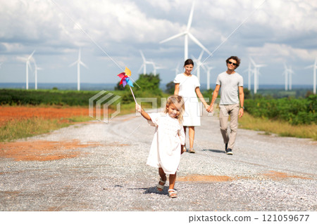 Happiness family walking wind turbine farm while father and daughter mother walking together. Happiness family walking wind turbine farm while father and daughter mother walking together. 121059677