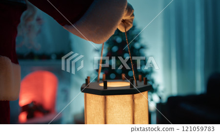 Santa Claus approaches Christmas tree in the night 121059783